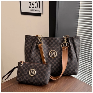 Brown monogram tote bag set with matching pouch and gold M logo in home setting