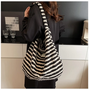 Detail of soft black and white striped knit hobo bag texture with a spacious slouchy design