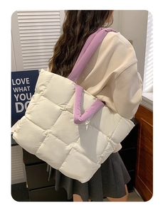 Quilted cotton tote bag in off-white with purple handles shown in a lifestyle shoulder view