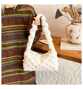 Close-up of white plush shoulder bag featuring a unique 3D popcorn knit texture detail