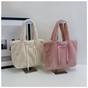 Detail of plush tote bags in beige and rose pink with decorative drawstring bows