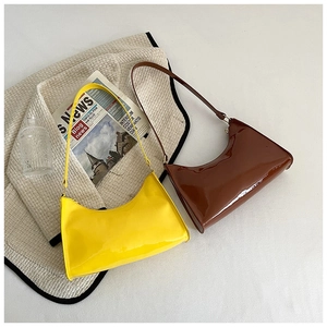 Gros plan sur des sacs baguette en cuir verni brillant aux couleurs jaune et marron