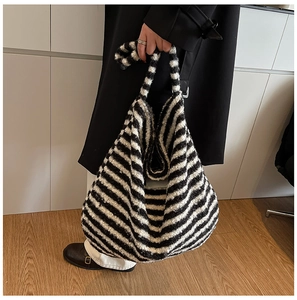 Close-up detail of soft black and white striped plush tote bag with textured fabric