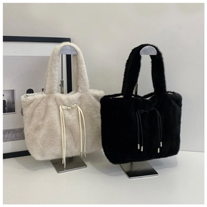 Detail view of plush faux fur tote bags in beige and black with decorative drawstring bows