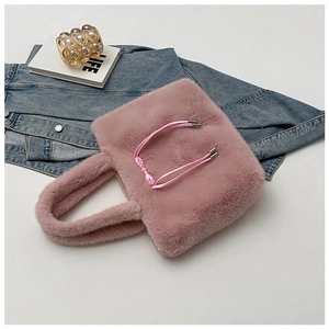 Close-up of pink fluffy plush tote bag with soft faux fur texture and matching handles