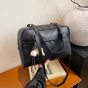 Retro black minimalist tote bag with synthetic leather texture and baseball pendant