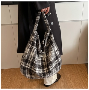 Close-up of a large black and white checkered fuzzy tote bag with thick plush texture