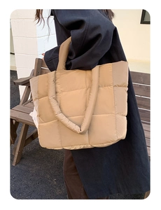 Detailed close-up showing the soft quilted texture and large capacity of the khaki tote bag