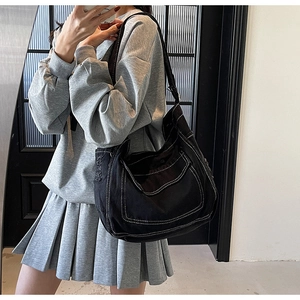 Selfie miroir montrant un grand sac fourre-tout en toile noire avec surpiqûres blanches