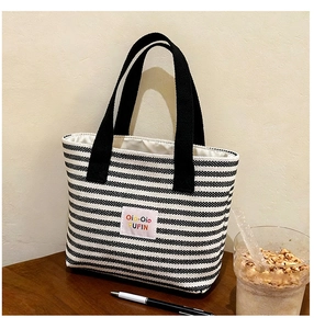Close-up of black and white striped canvas tote bag with a colorful logo on the front