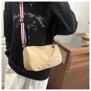 Dettaglio borsa a tracolla in nylon kaki con ampia tracolla a righe rosse bianche blu