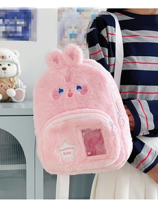 Détails d'un sac à dos lapin en peluche rose avec fenêtre PVC transparente et broderie d'étoile