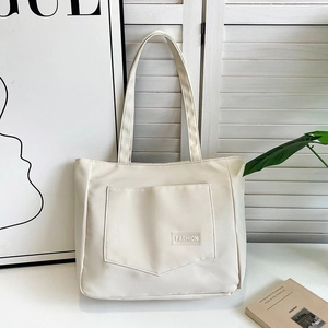 Detail of off-white nylon tote bag with fashion patch pocket and textured material