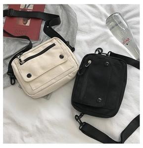 Close-up of dual-color canvas crossbody bags with front flap pockets and adjustable straps