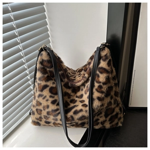 Detail of plush leopard print tote bag showing soft faux fur texture and black leather straps