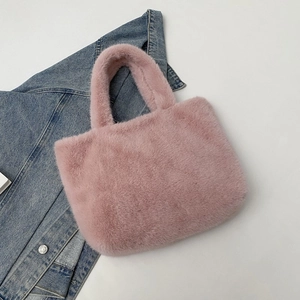 Pink plush faux fur tote bag for women shown on a denim jacket background