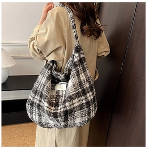 Close-up of black and white plaid plush shoulder bag with BEEYOU woven label detail
