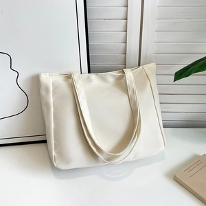 Minimalist white nylon tote bag shown on a white table with elegant home decor