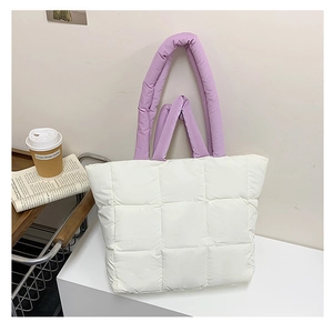 Macro detail of quilted puffy tote bag texture with lavender purple padded handle