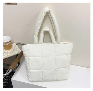 Detailed view of white quilted puffer tote bag with large square stitching and dual handles