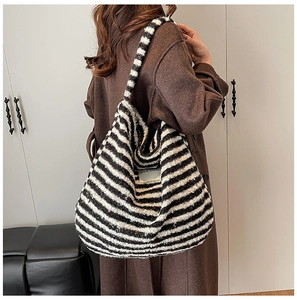 Detail of a plush black and white striped hobo bag shown from a stylish side view angle