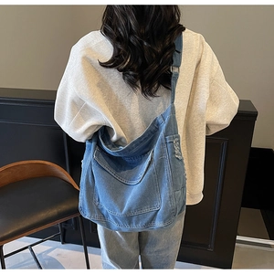 Détail d'un sac cabas en denim bleu clair avec bords effilochés tendance et bandoulière