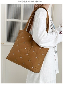 Close-up of brown quilted tote bag featuring white bow patterns and soft fabric texture