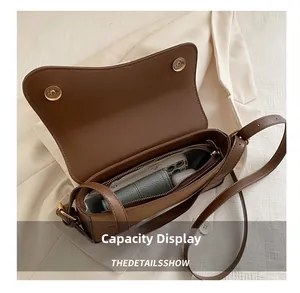 Vue intérieure du sac bandoulière en cuir marron montrant sa capacité de rangement
