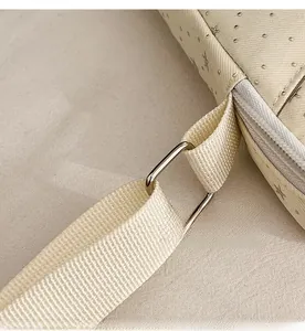 Detail of beige crossbody bag showing silver star pattern and durable metal square ring