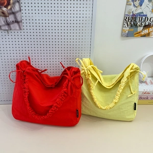 Minimalist nylon crossbody cloud bag with ruffle drawstring straps in red and yellow