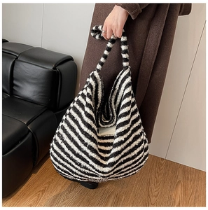 Detailed texture of black and white striped plush faux fur tote bag with wide handle