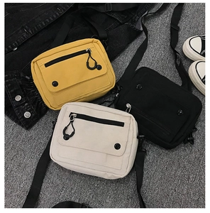 Flat lay of canvas crossbody bags in yellow, black and white with adjustable straps
