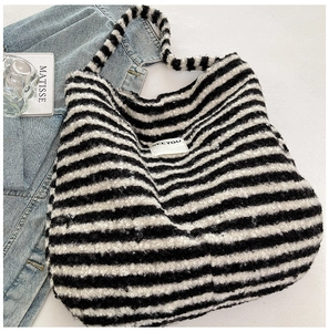 Detailed macro view of the fluffy black and white striped tote bag with SEEYOU label detail