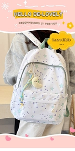 Close-up of white star pattern backpack with moon charm and letter A accessory