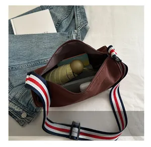 Vista dall'alto della borsa a secchiello in nylon marrone con interno capiente per oggetti