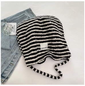 Flat lay of a fluffy black and white striped knit tote with a SEEYOU woven label