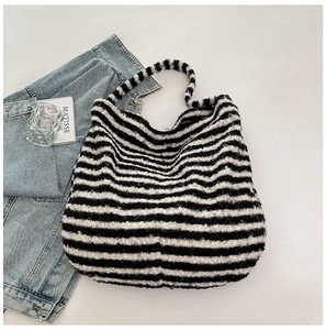 Detailed macro texture of a large capacity black and white fuzzy striped tote shoulder bag