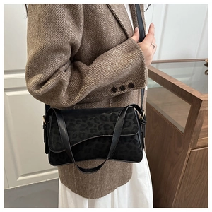 Vue détaillée du sac bandoulière en daim à imprimé léopard porté avec un blazer brun