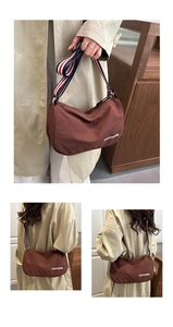 Dettaglio borsa a mezzaluna in nylon marrone scuro con logo e tracolla larga a strisce