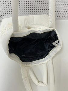 White quilted puffer tote bag with spacious interior and long padded handles