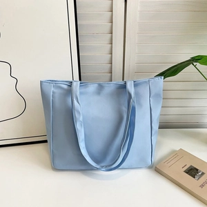 Close-up of light blue nylon tote bag placed on a table with fresh summer decor
