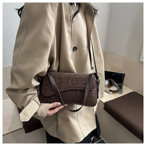 Détail d'un sac à bandoulière vintage à imprimé léopard avec deux lanières en cuir
