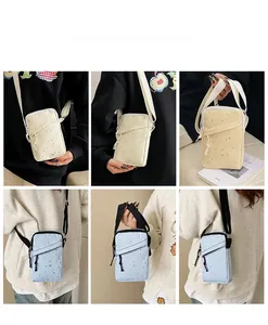 Close-up of small canvas crossbody phone bag featuring star pattern and zipper pocket