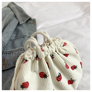 Detail der weißen Cordtasche mit Erdbeerdruck und Kordelzug aus Baumwollseilen