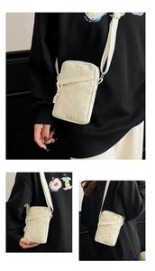 Detail view of cream star patterned vertical phone bag with adjustable fabric strap