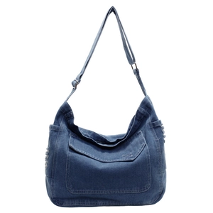 Sac fourre-tout en denim bleu foncé avec grande poche avant et bandoulière réglable sur fond blanc