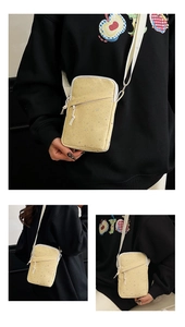 Detail of light yellow crossbody phone bag featuring silver star print and woven strap