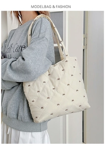 Detail view of quilted tote bag with bow embroidery showing its large capacity and scale