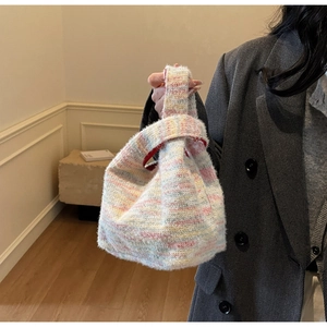 Detail of colorful rainbow striped plush mini handbag with a red inner lining