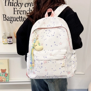 Detail of white star pattern backpack with yellow moon plush charm and pink strap